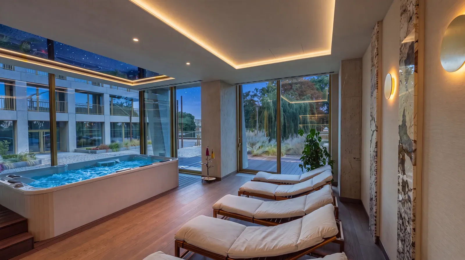 Wellnessbereich am Abend: Jacuzzi und Liegen